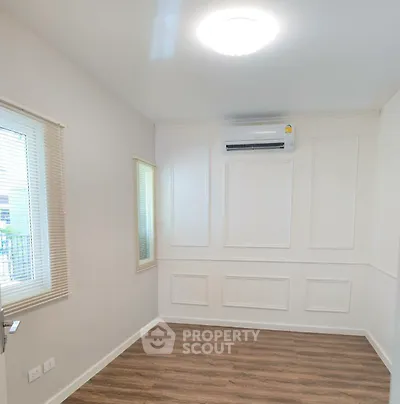 Bright and airy room with elegant paneling and modern air conditioning unit, perfect for a cozy living space.