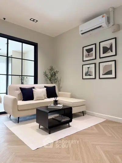 Modern living room with stylish decor, featuring a cozy sofa, chic artwork, and elegant flooring.
