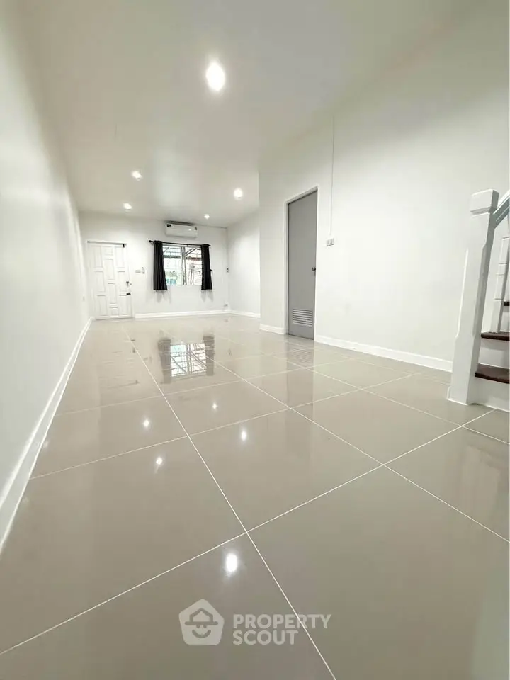 Spacious modern living room with glossy tiled floors and neutral decor