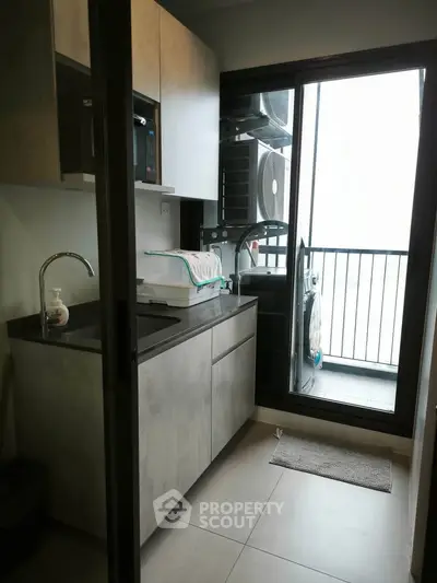 Modern kitchen with sleek cabinetry and balcony view