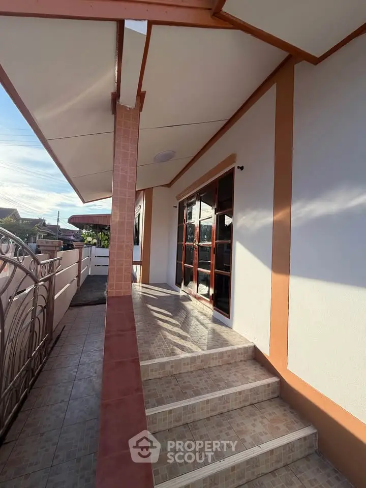 Charming exterior view of a modern home with tiled steps and large windows, perfect for welcoming guests.