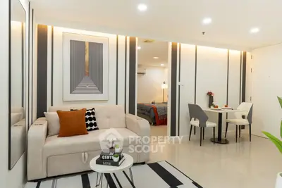 Modern living room with stylish decor and cozy dining area in open-plan apartment.