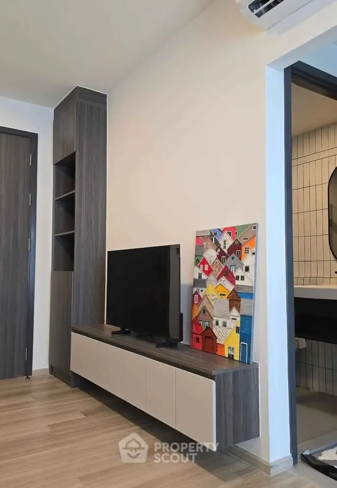 Modern living room with sleek TV stand and colorful wall art, showcasing contemporary interior design.