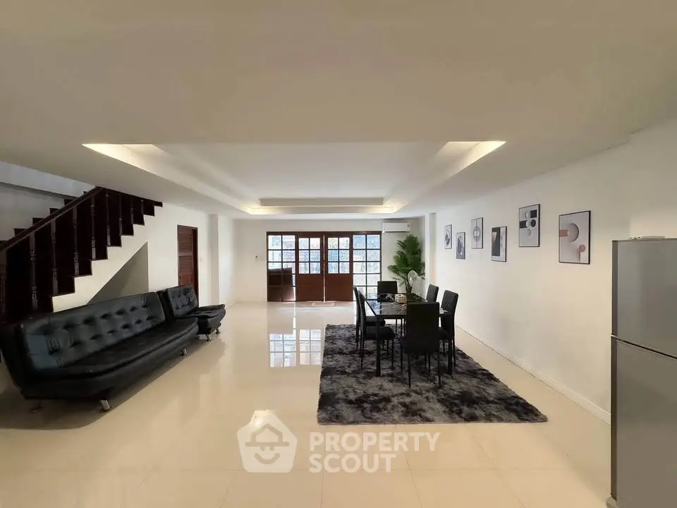 Spacious modern living room with sleek furniture and elegant dining area, perfect for entertaining.