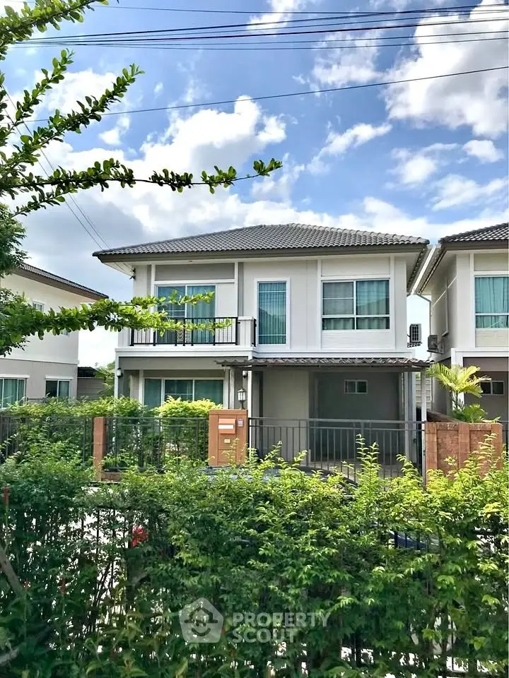 Charming two-story suburban house with lush greenery and modern design.