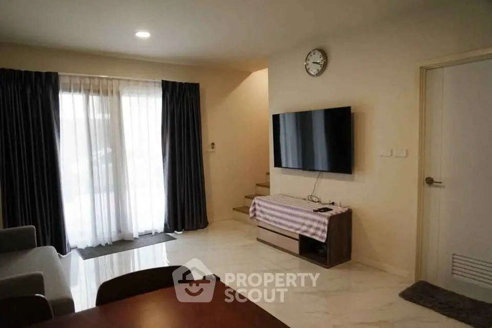 Modern living room with sleek TV setup and elegant curtains