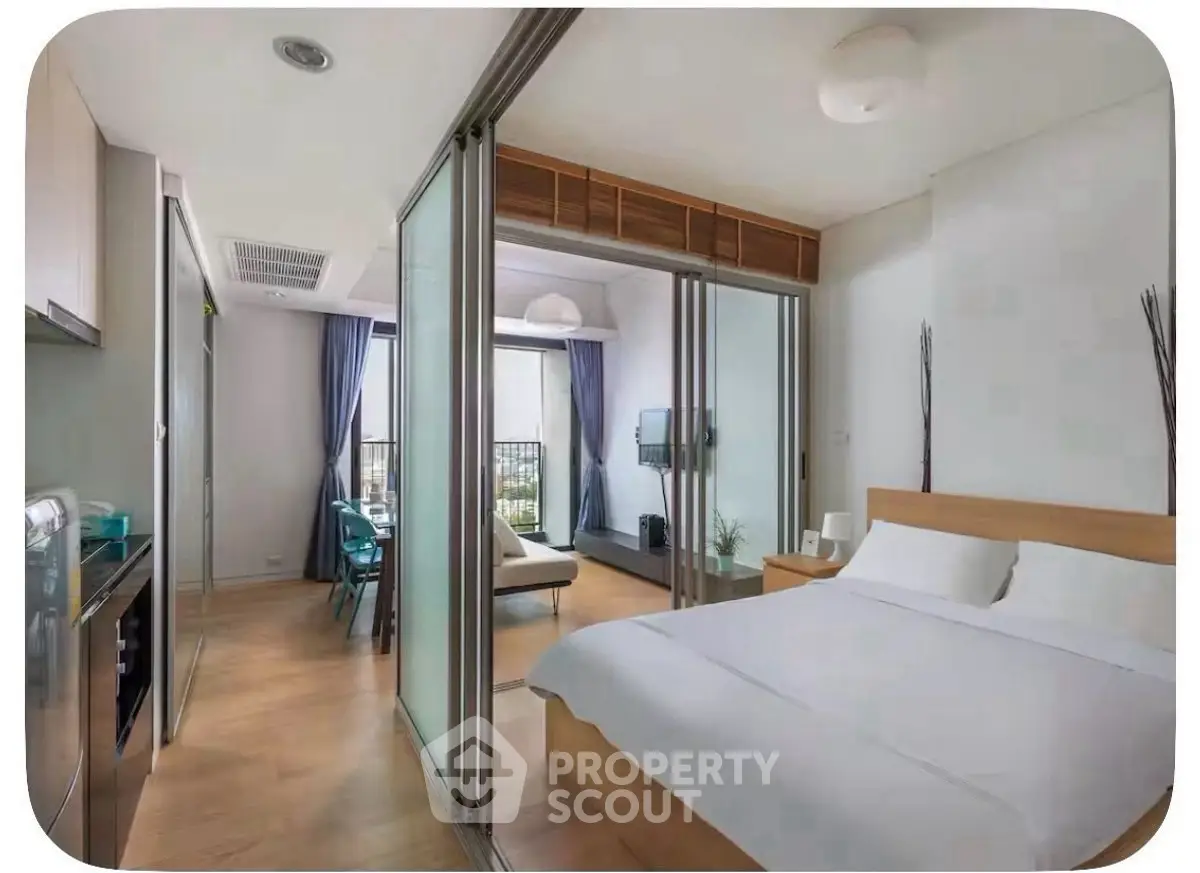 Modern apartment interior with bedroom and living area, featuring sleek design and natural light.