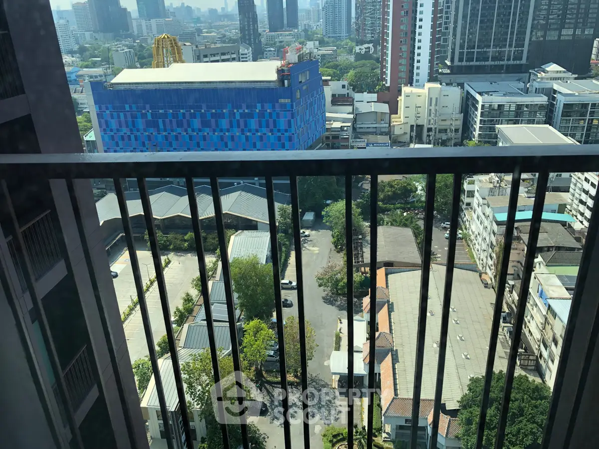 Stunning cityscape view from high-rise balcony overlooking urban skyline and vibrant buildings.