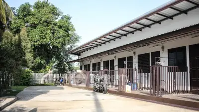Charming single-story building with gated entrances and lush greenery
