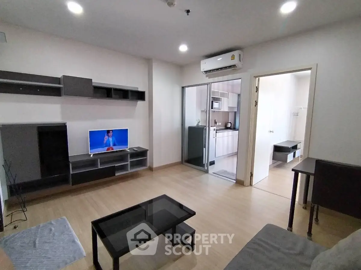 Modern living room with sleek furniture and open kitchen layout in a stylish apartment.