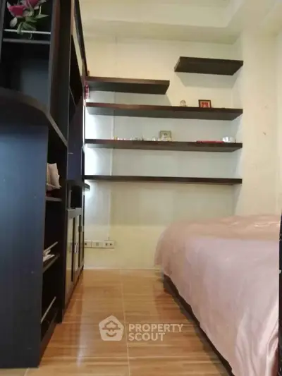 Cozy bedroom with modern shelving and wooden flooring, perfect for a minimalist lifestyle.