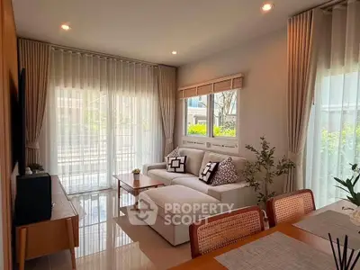 Charming living room with elegant decor, large windows, and cozy seating area, perfect for relaxation.