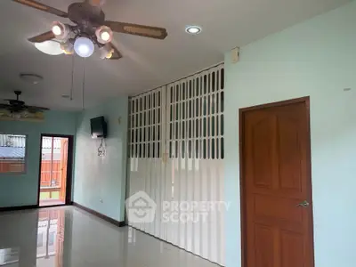 Spacious living room with ceiling fan and sliding doors leading to a balcony.