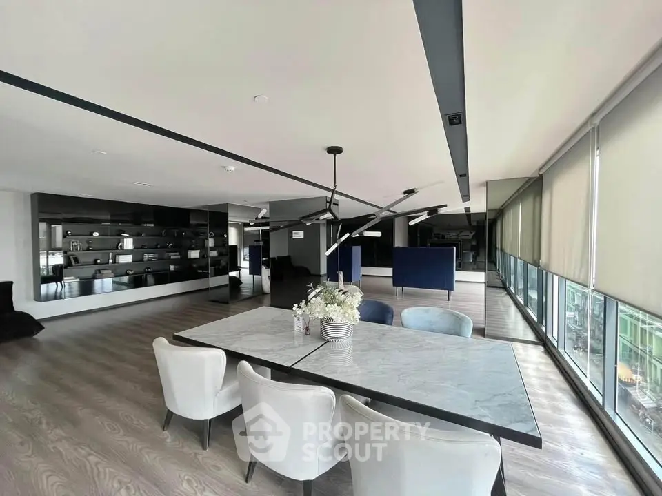 Spacious modern living room with elegant dining area and large windows offering natural light.