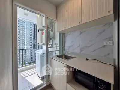 Modern kitchen with balcony view and washing machine in high-rise apartment