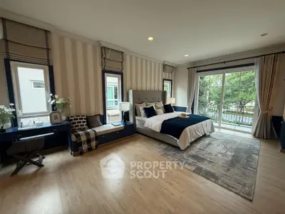 Luxurious bedroom with elegant decor and large windows overlooking greenery.
