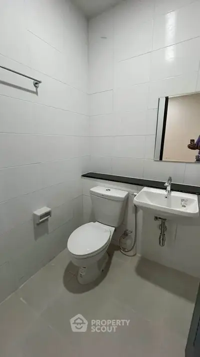 Modern bathroom with white tiles and sleek fixtures