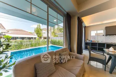 Luxurious living room with pool view in modern home, featuring elegant decor and abundant natural light.