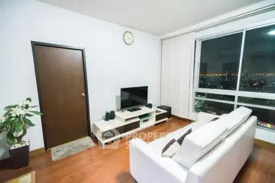 Modern living room with city view, sleek furniture, and hardwood floors.
