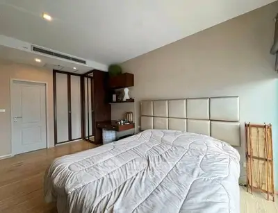Spacious bedroom with modern decor and ample natural light, featuring a cozy bed and stylish furnishings.