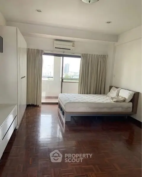 Spacious bedroom with balcony view in modern apartment