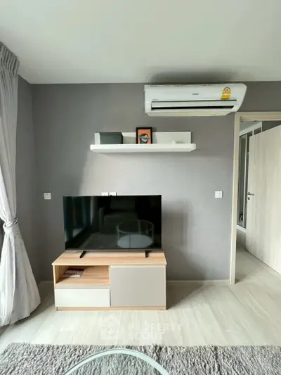 Modern living room with sleek TV setup and air conditioning unit