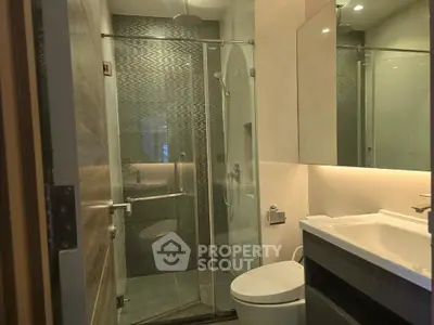 Modern bathroom with glass shower and sleek fixtures in a contemporary apartment.