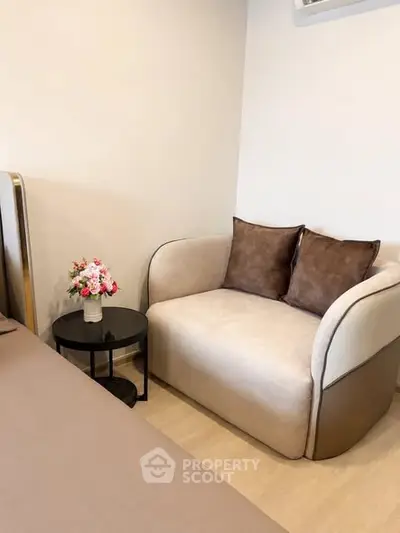 Cozy bedroom corner with plush loveseat and elegant side table