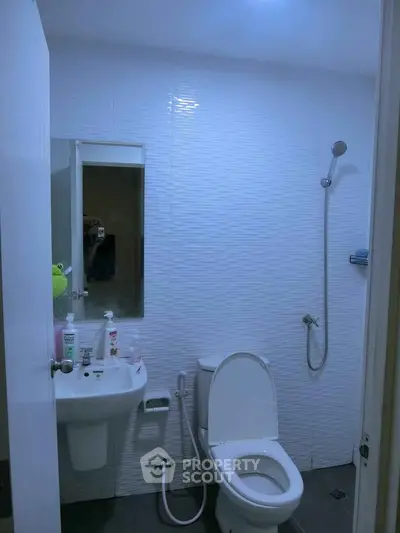 Modern bathroom with sleek white tiles and essential fixtures