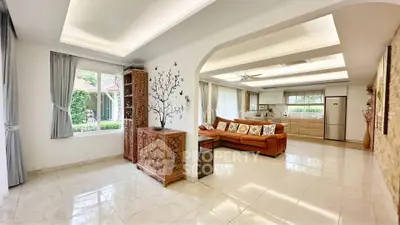 Spacious open-plan living room with elegant decor and modern kitchen