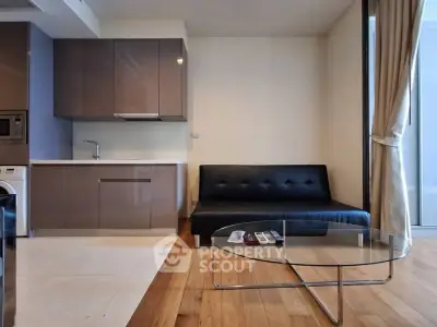 Modern living room with sleek kitchen and stylish furniture in open layout apartment.