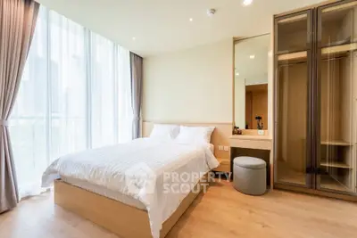 Modern bedroom with large windows and stylish wardrobe in a high-rise apartment.