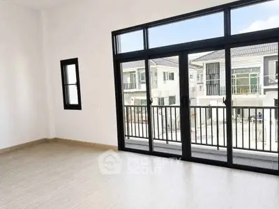 Spacious modern living room with large windows and balcony view in a contemporary home.