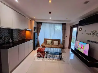 Modern living room with open kitchen, sleek design, and cozy seating area.