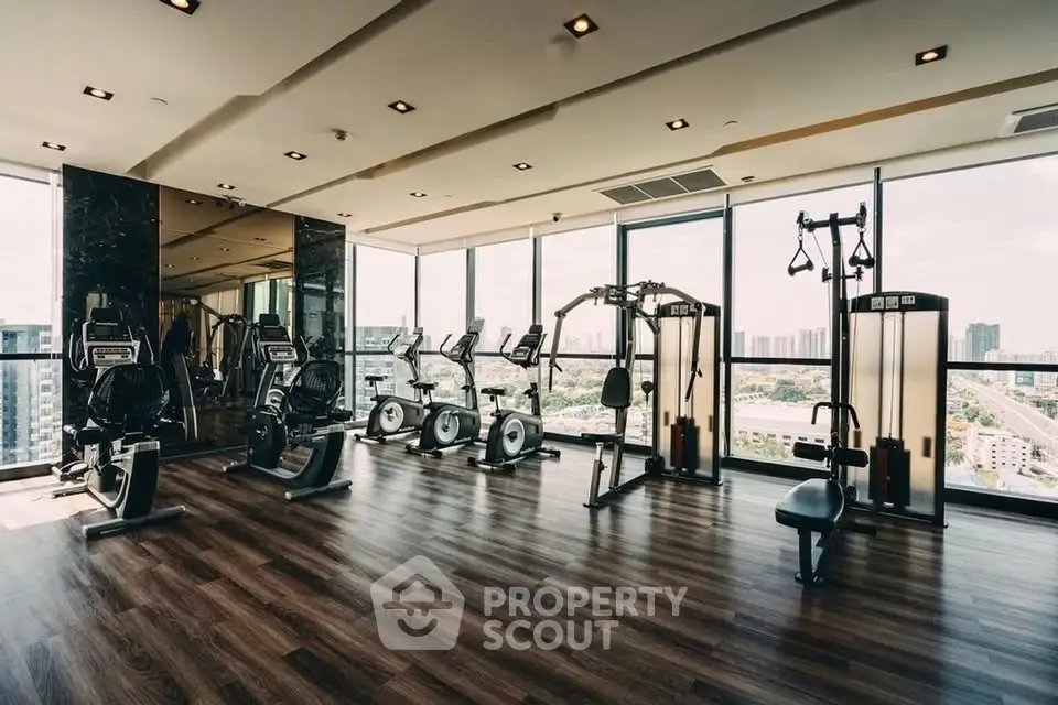 Luxurious high-rise gym with panoramic city views and modern fitness equipment.