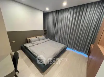 Modern bedroom with sleek design and cozy ambiance, featuring a large bed and stylish curtains.