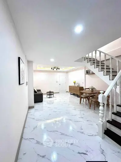 Spacious modern living room with elegant staircase and marble flooring