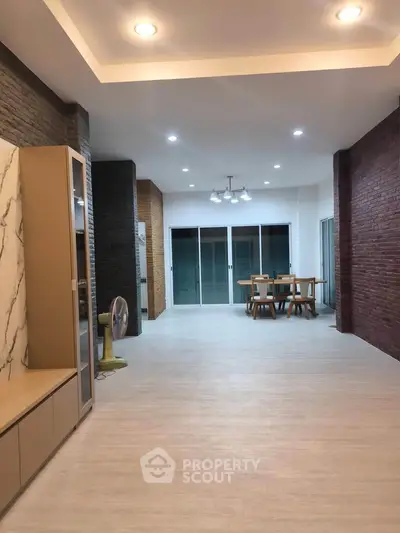 Spacious modern living area with stylish dining set and ambient lighting.