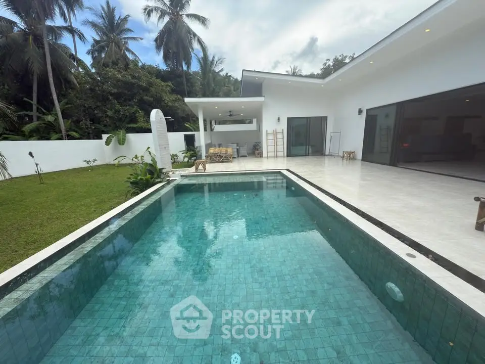 Luxurious modern villa with private pool and lush garden in tropical paradise.