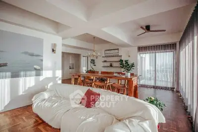 Spacious living room with elegant decor and large windows offering abundant natural light.
