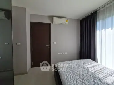Modern bedroom with air conditioning and natural light, featuring sleek design and comfortable ambiance.