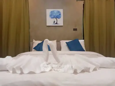 Elegant bedroom with artistic decor and swan towel arrangement, perfect for a cozy retreat.