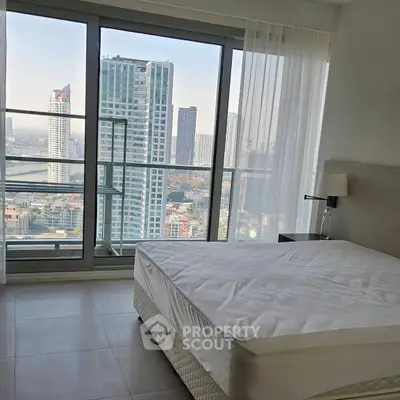 Modern bedroom with stunning city view and floor-to-ceiling windows in high-rise apartment.