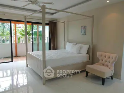 Spacious bedroom with canopy bed and balcony access in modern home.