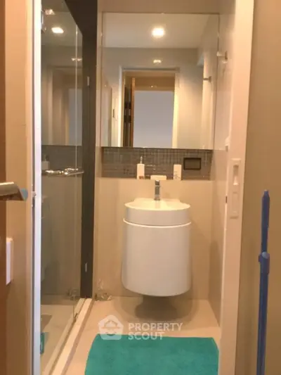 Modern bathroom with sleek fixtures and a glass shower enclosure, featuring a stylish vanity and bright decor.