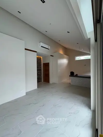 Spacious modern living room with high ceilings and sleek tile flooring