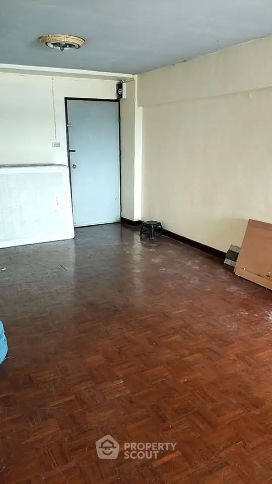 Spacious empty room with wooden flooring and simple decor