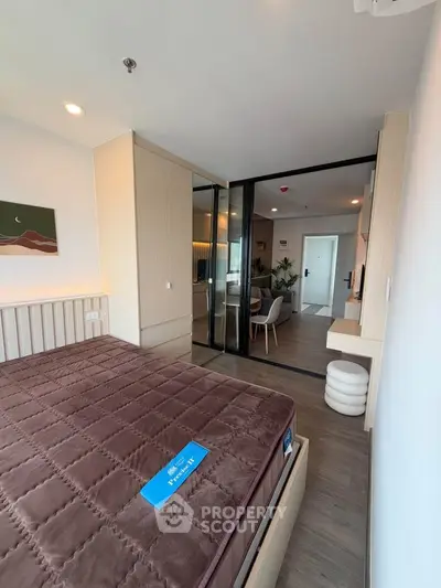 Modern bedroom with stylish decor and glass partition leading to dining area