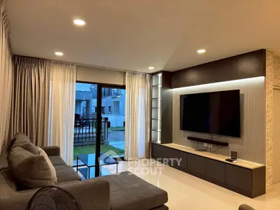 Modern living room with sleek design, large TV, and cozy seating area, perfect for relaxation and entertainment.