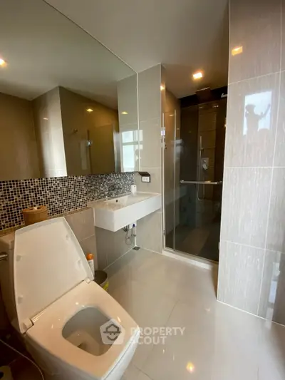 Modern bathroom with sleek fixtures and glass shower enclosure